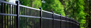 An aluminum, black painted fence stretching down the side of yard.