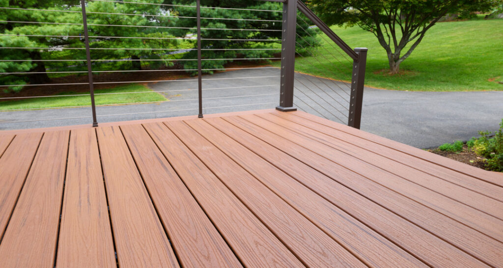 A close up shot of composite decking with metal wire railings.