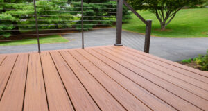 A close up shot of composite decking with metal wire railings.