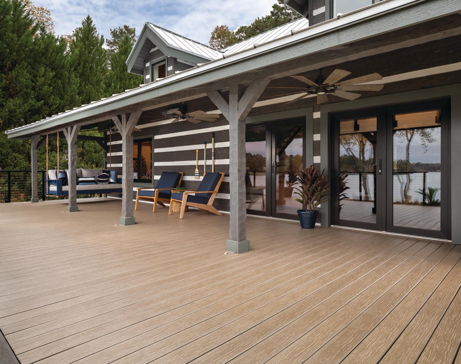 Looking at a side patio of a beautifully designed lake house.