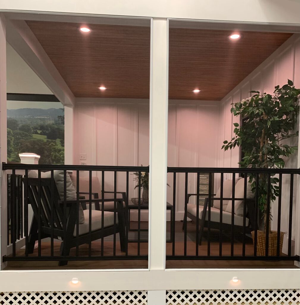 A showroom shot featuring a staged deck, white framing, black fencing, and dark wood accents help create a modern look.