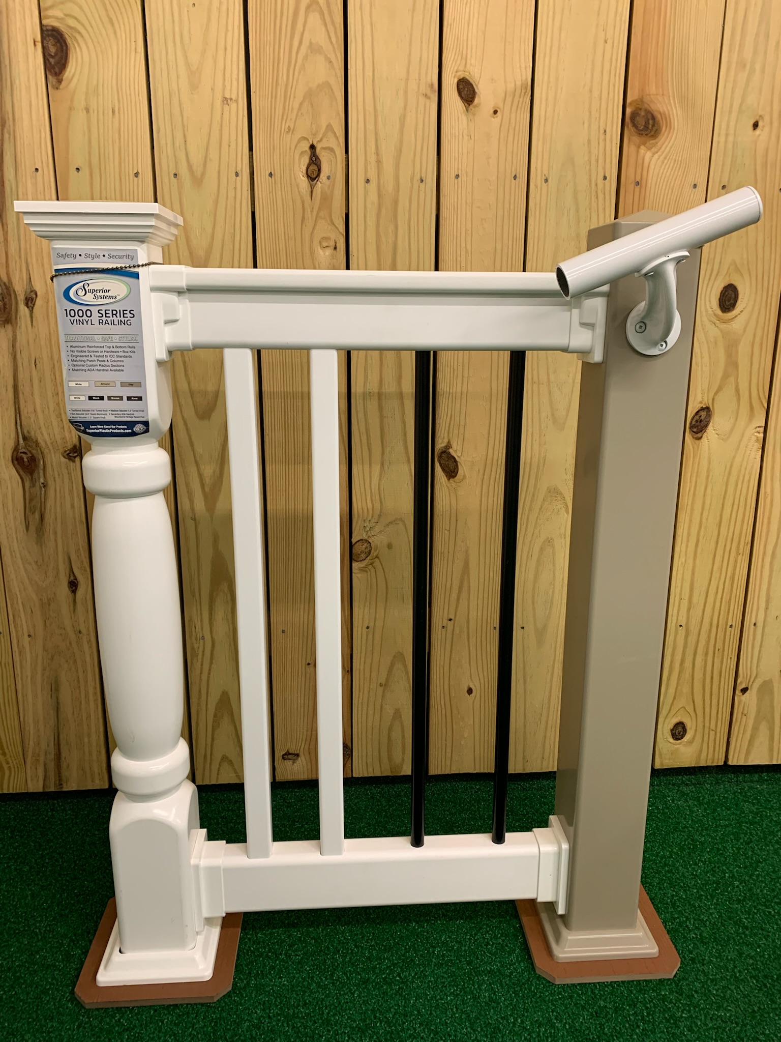 A white, composite fence sample for a deck featuring a railing for easy stair stepping.