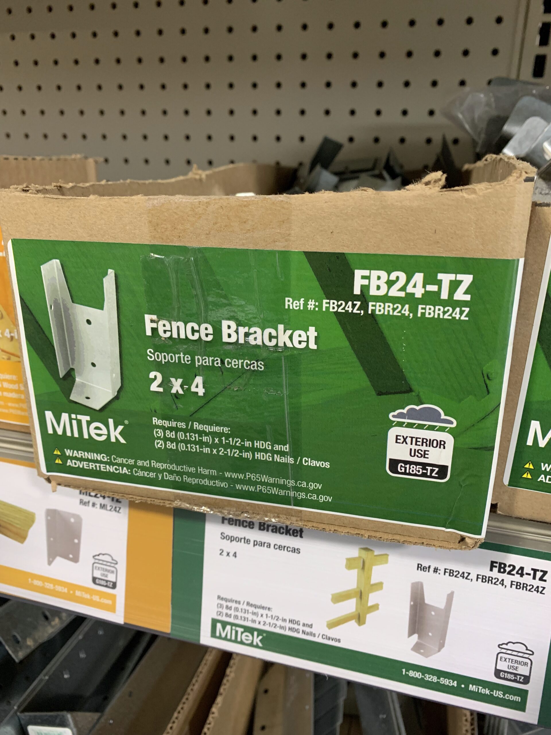 A box containing 2x4 white fence brackets.