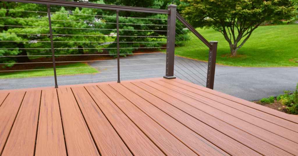 A close up shot of composite decking with metal wire railings.