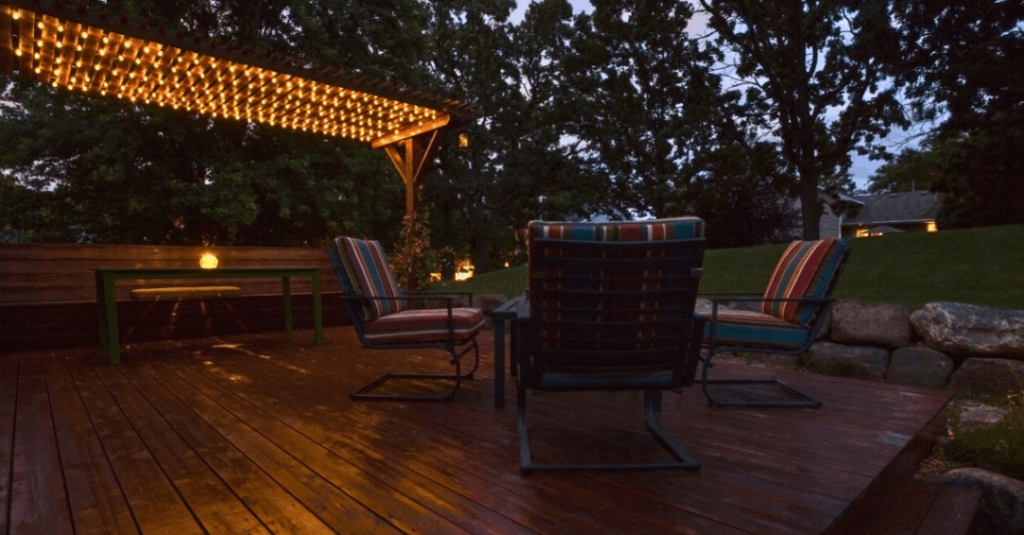 An open layout deck with chairs grouped off to the side as the night begins.