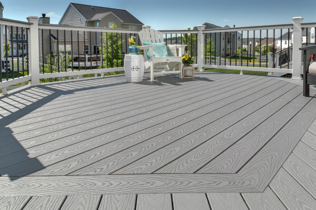 A close up shot of gray decking contrasted by a white deck rail with black guard rails.
