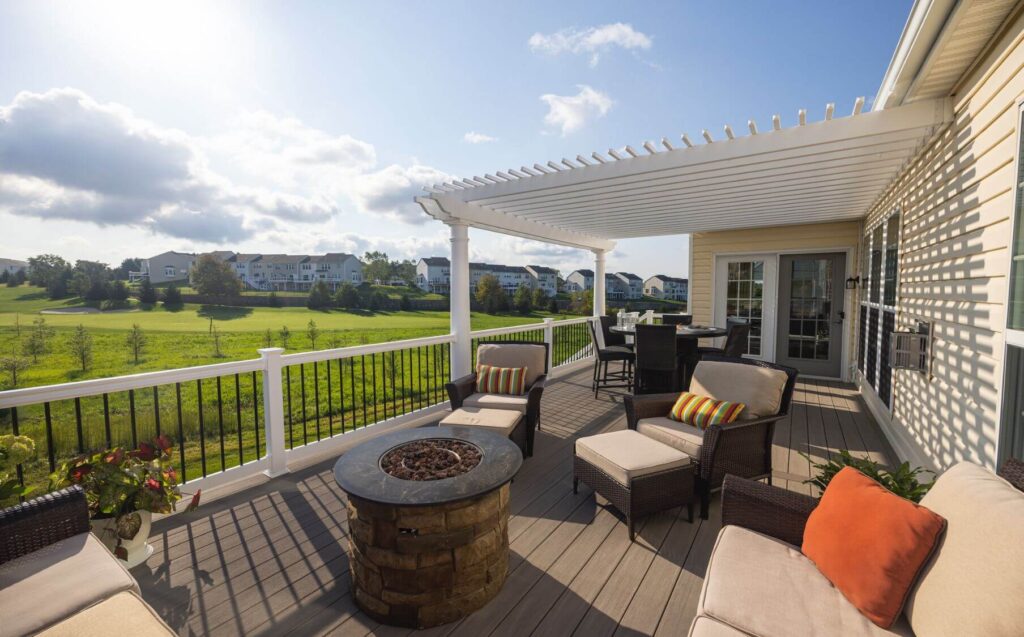 A beautifully designed deck featuring a white, composite fence with black bars & a brown composite deck to help bring contrast to the design.