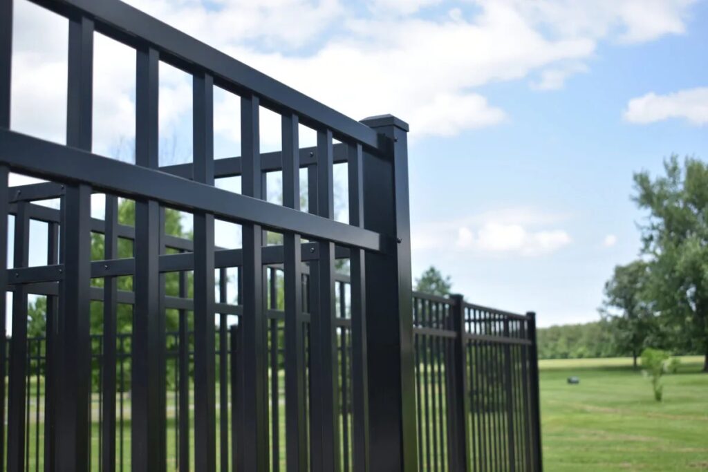 A close up photo of a a tall black aluminum fence.