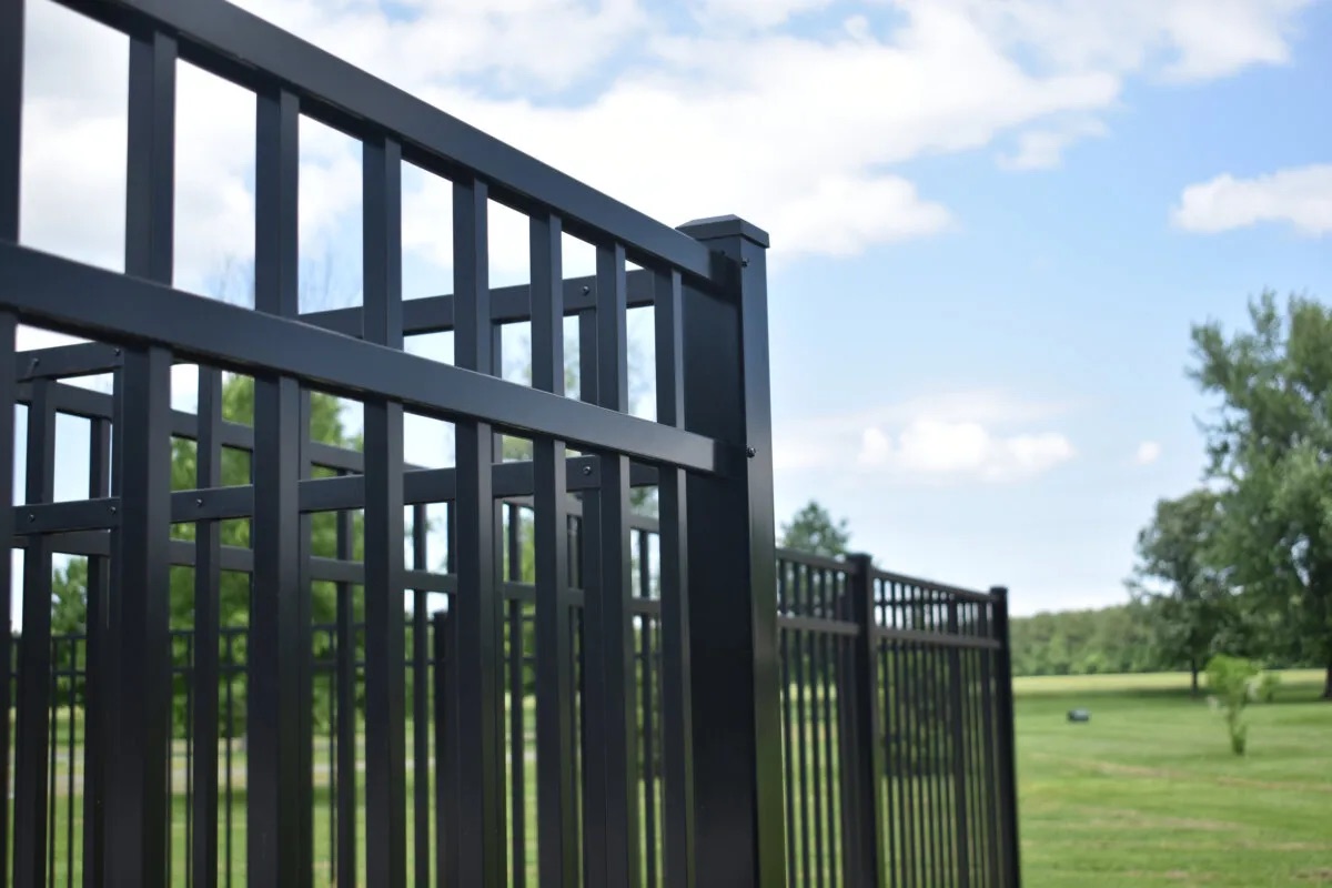 A close up photo of a a tall black aluminum fence.