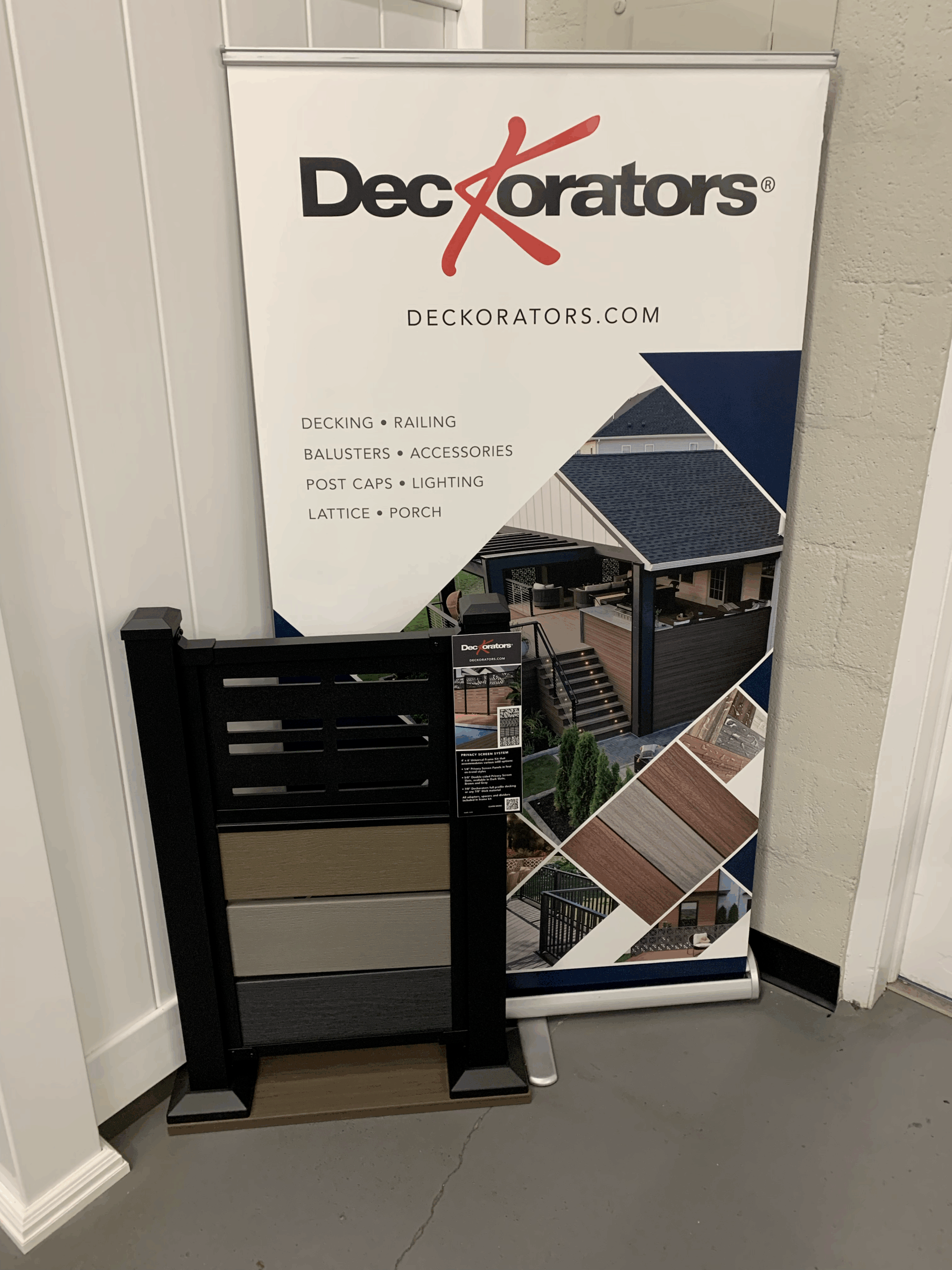 A DecKorators sample deck fence with store poster.
