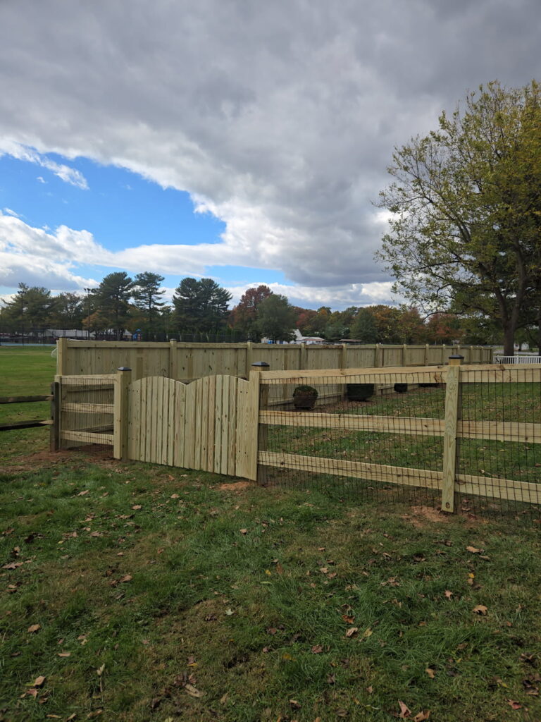 A custom designed and supplied wooden fence (with chicken wire) by Ladiesburg Lumber.