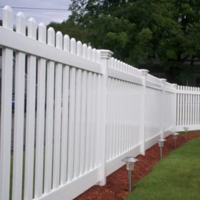 A tall white picket fence with small garden lights every few feet.