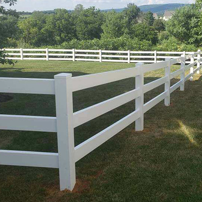 A white ranch rail enclosing a portion of yard.