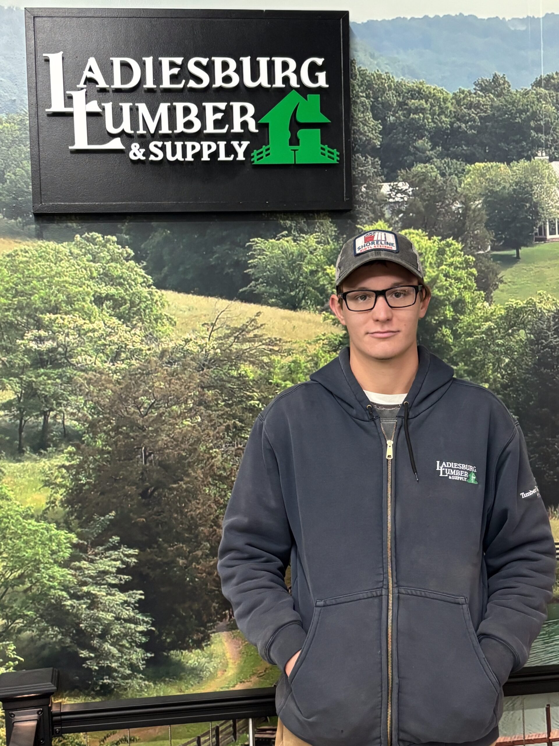 Matt Miller (Lumberyard) standing in front of an in store graphic.